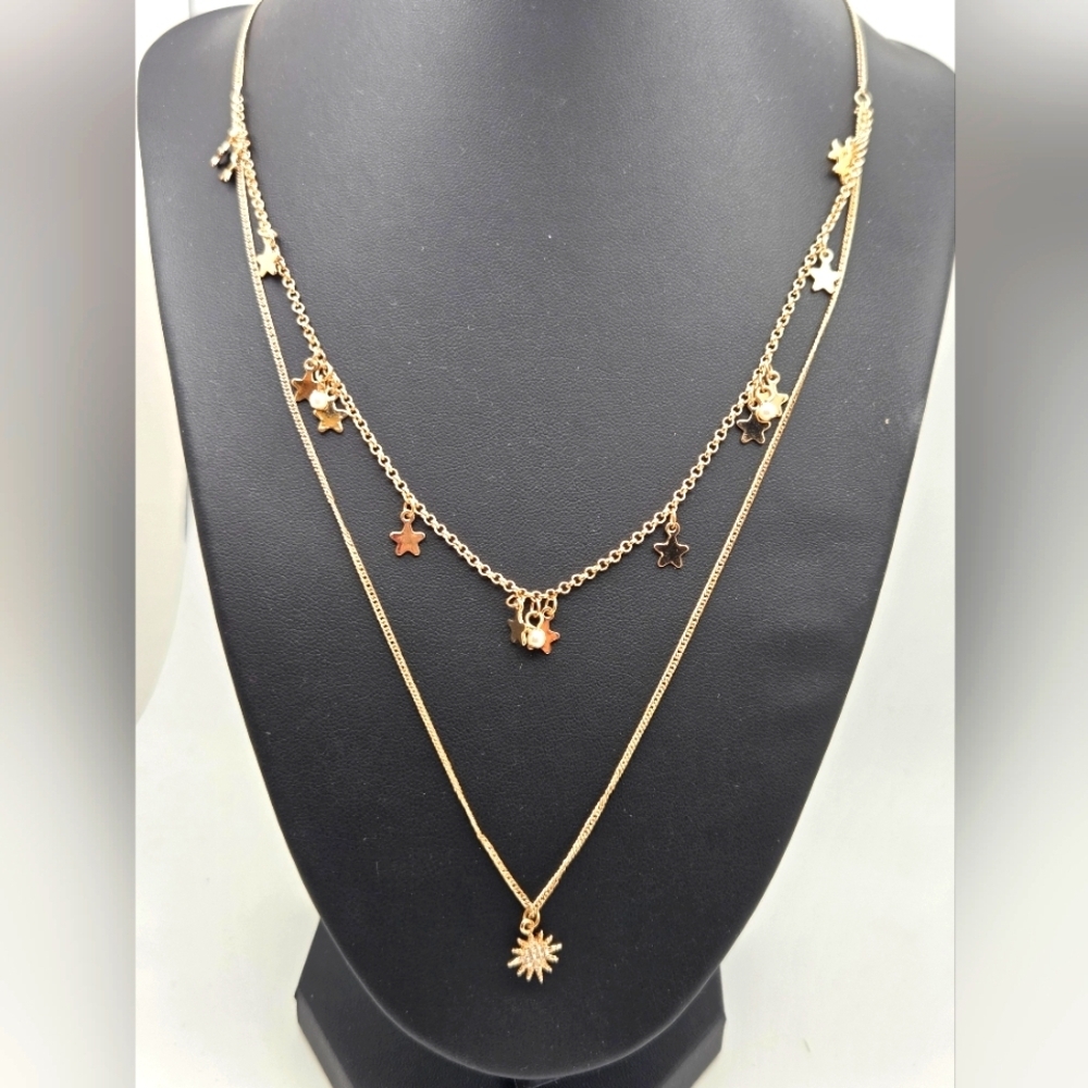 Delicate gold star doble strand necklace featuring a 1.3cm star pendant